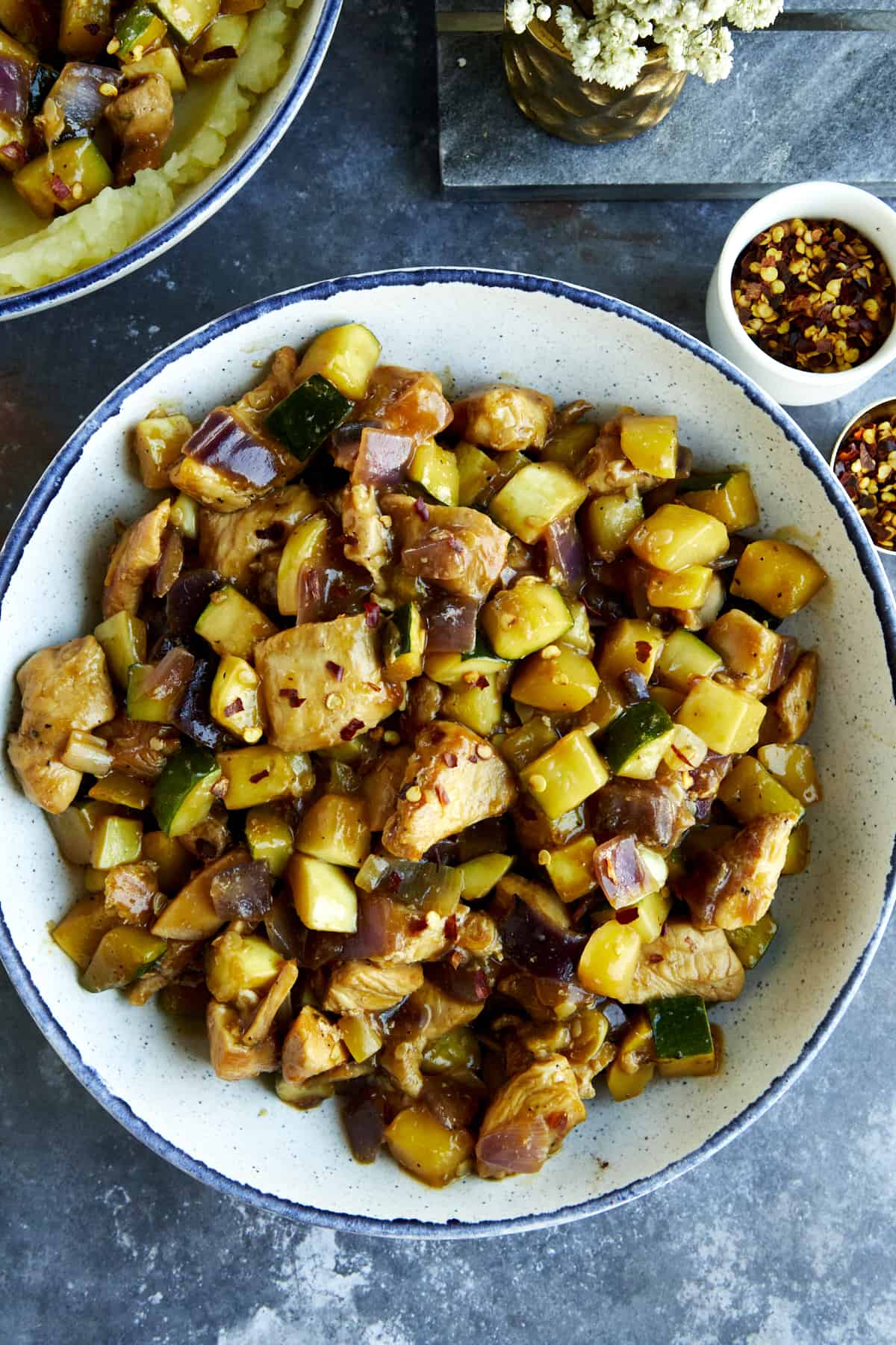 A bowl of chicken and zucchini stir fry. 
