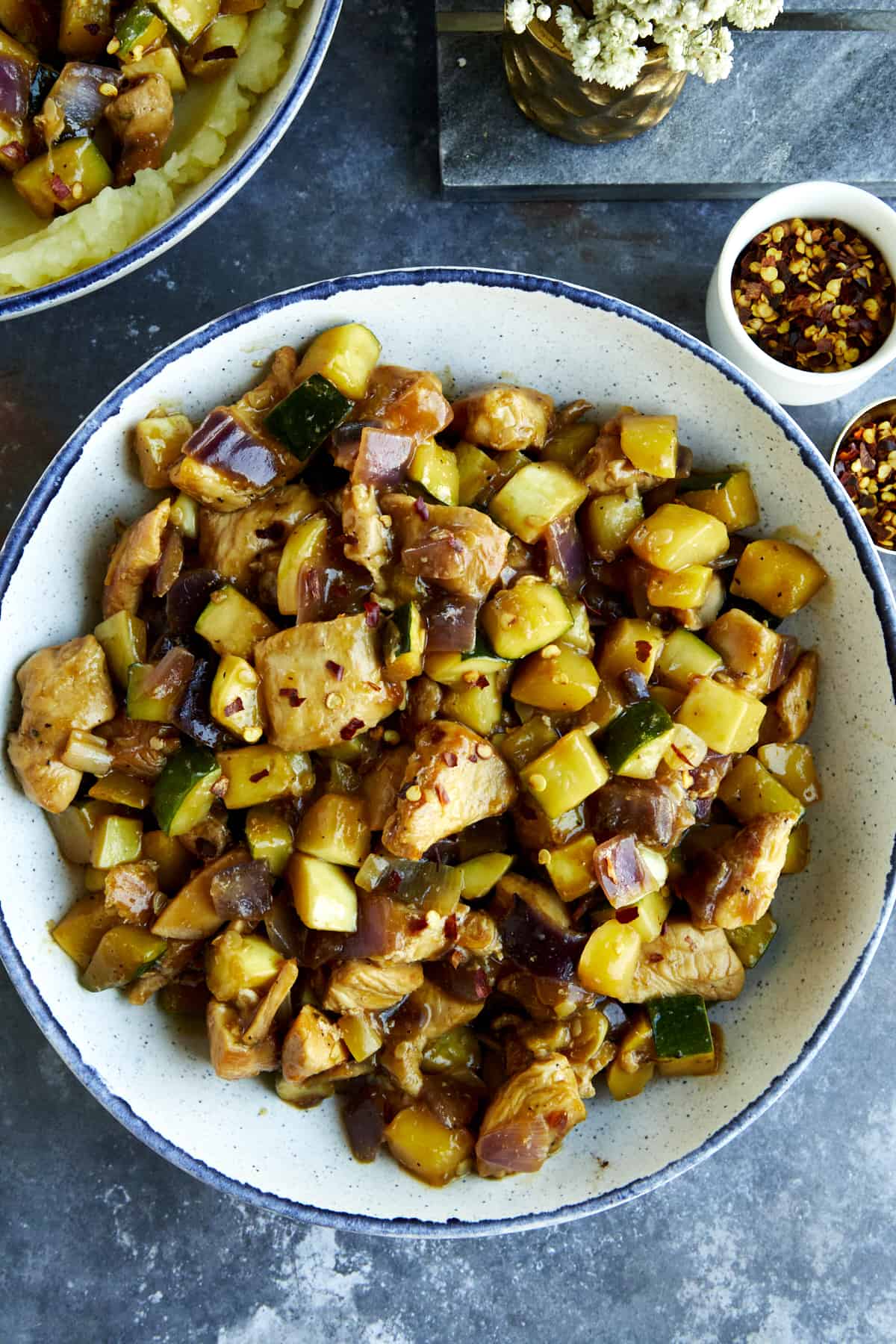 A bowl of chicken and zucchini stir fry.