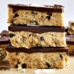 Three no-bake chocolate chip cookie dough bars on top of each other.