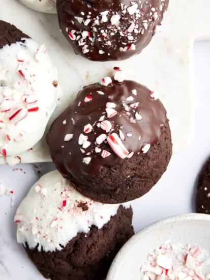 Chocolate peppermint cookies dipped in white and dark chocolate topped with candy cane pieces.