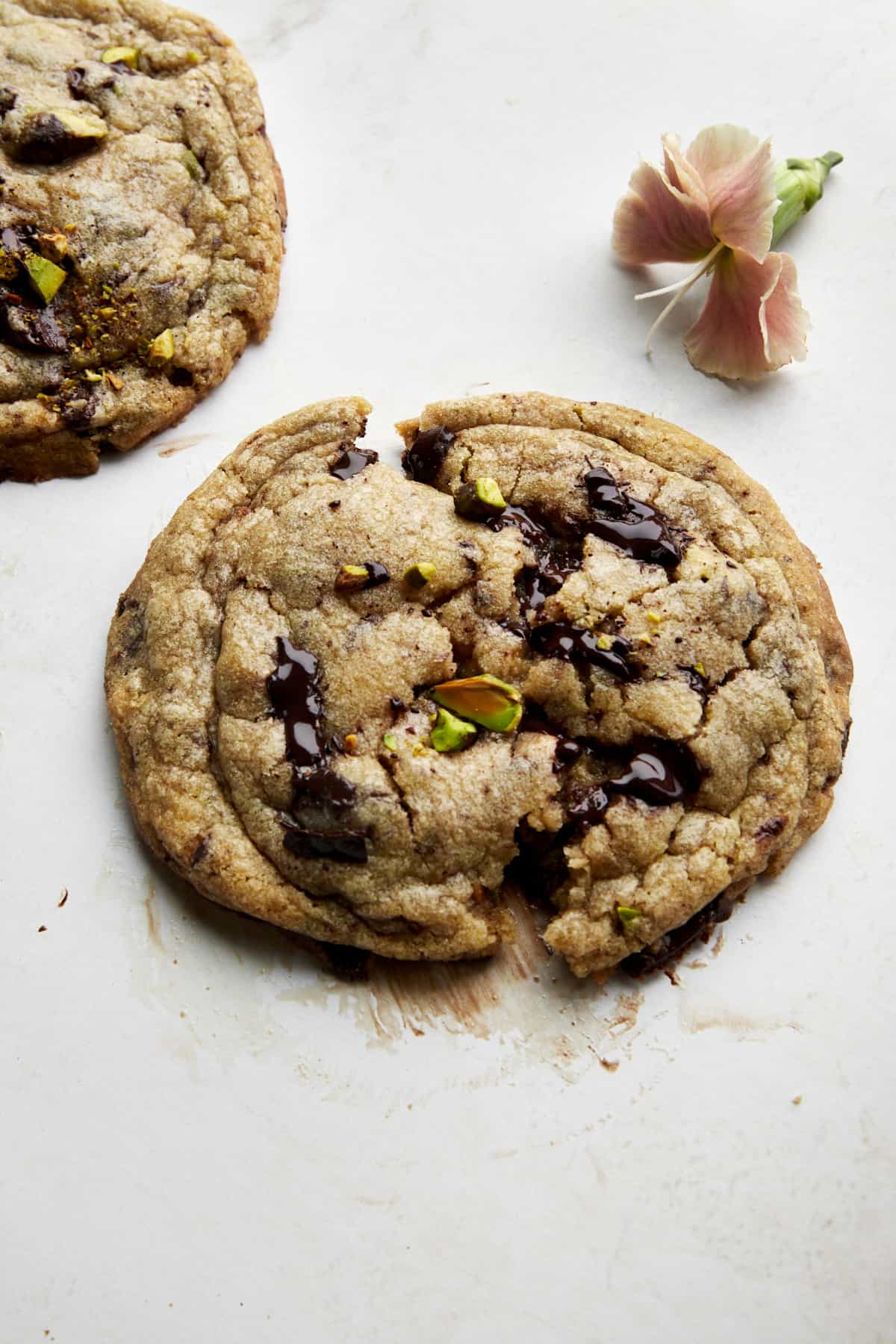 A pistachio chocolate chip cookie split in half. 