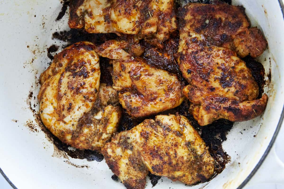 Seasoned chicken breasts seared in a pot. 