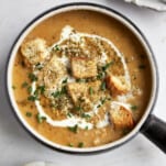 A bowl of roasted cauliflower soup topped with heavy cream, croutons, and za'atar.