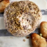 A Mediterranean cream cheese ball with a bite missing.