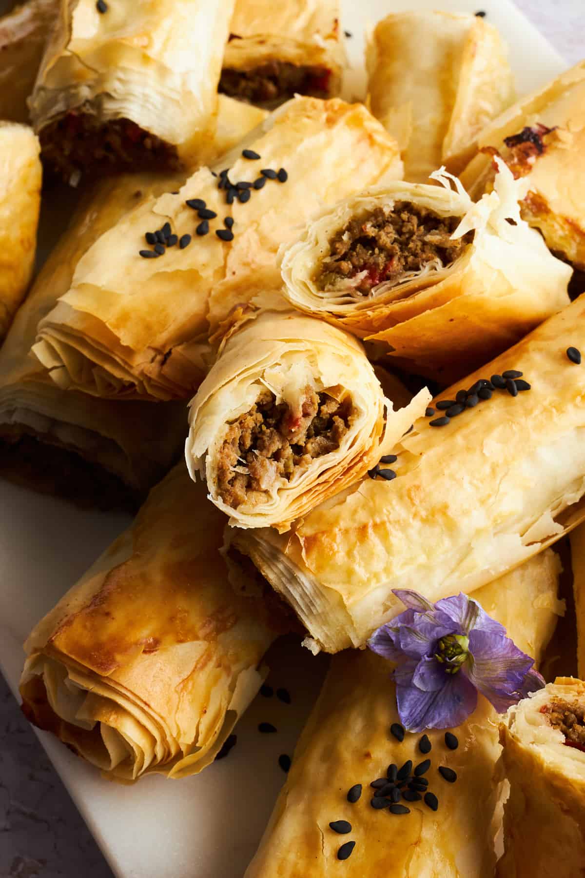 Phyllo rolls with ground beef with one split in half. 