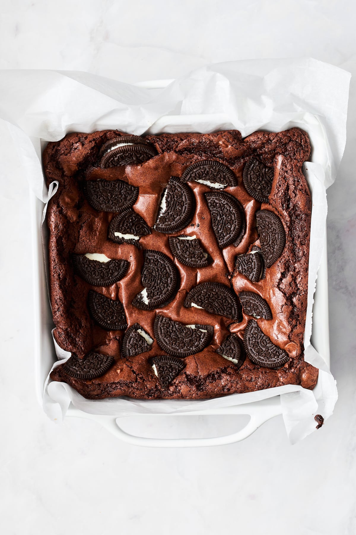 A baking dish full of brownies with Oreos on top. 