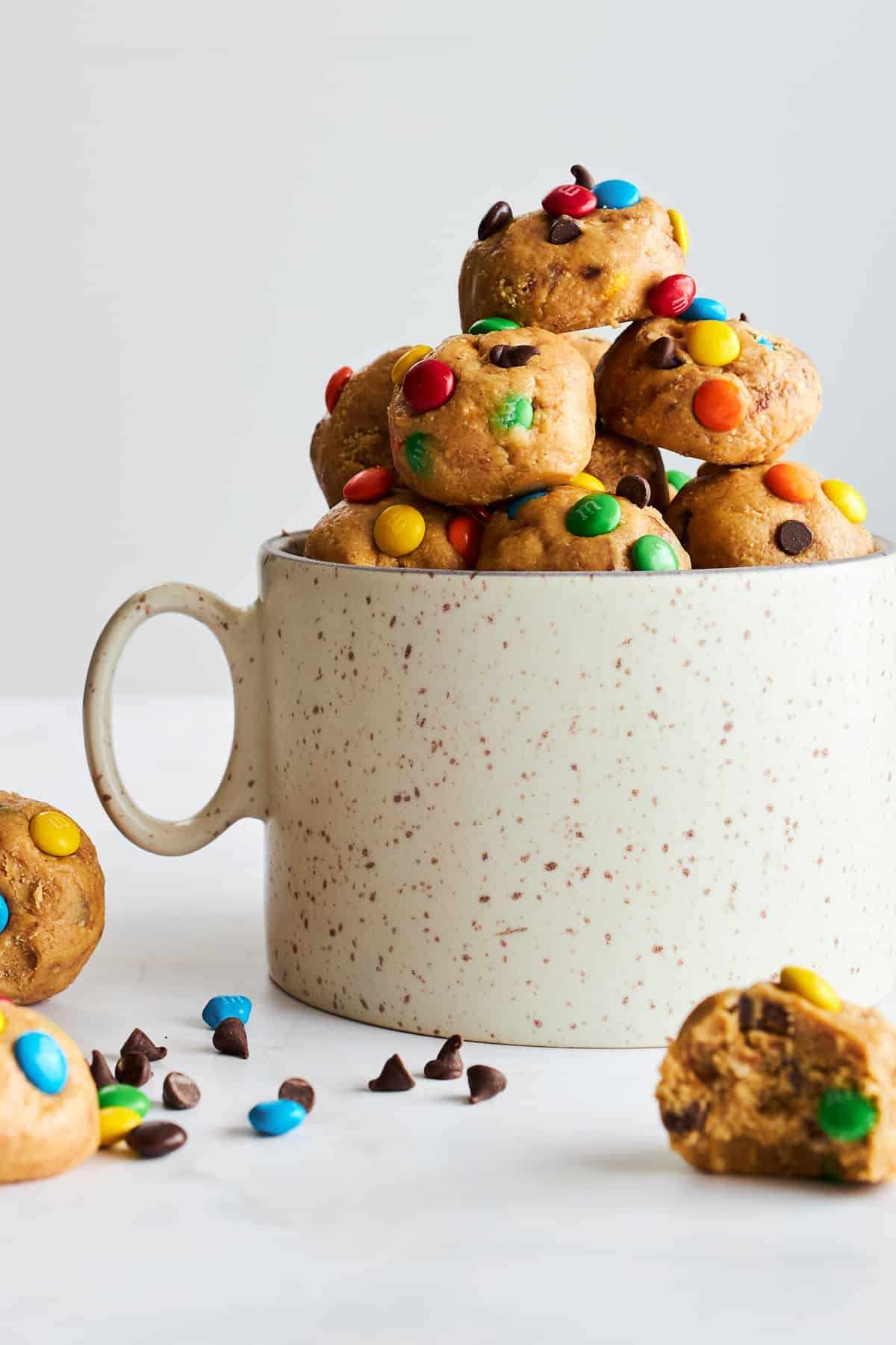 A mug full of no-bake monster cookie dough balls. 