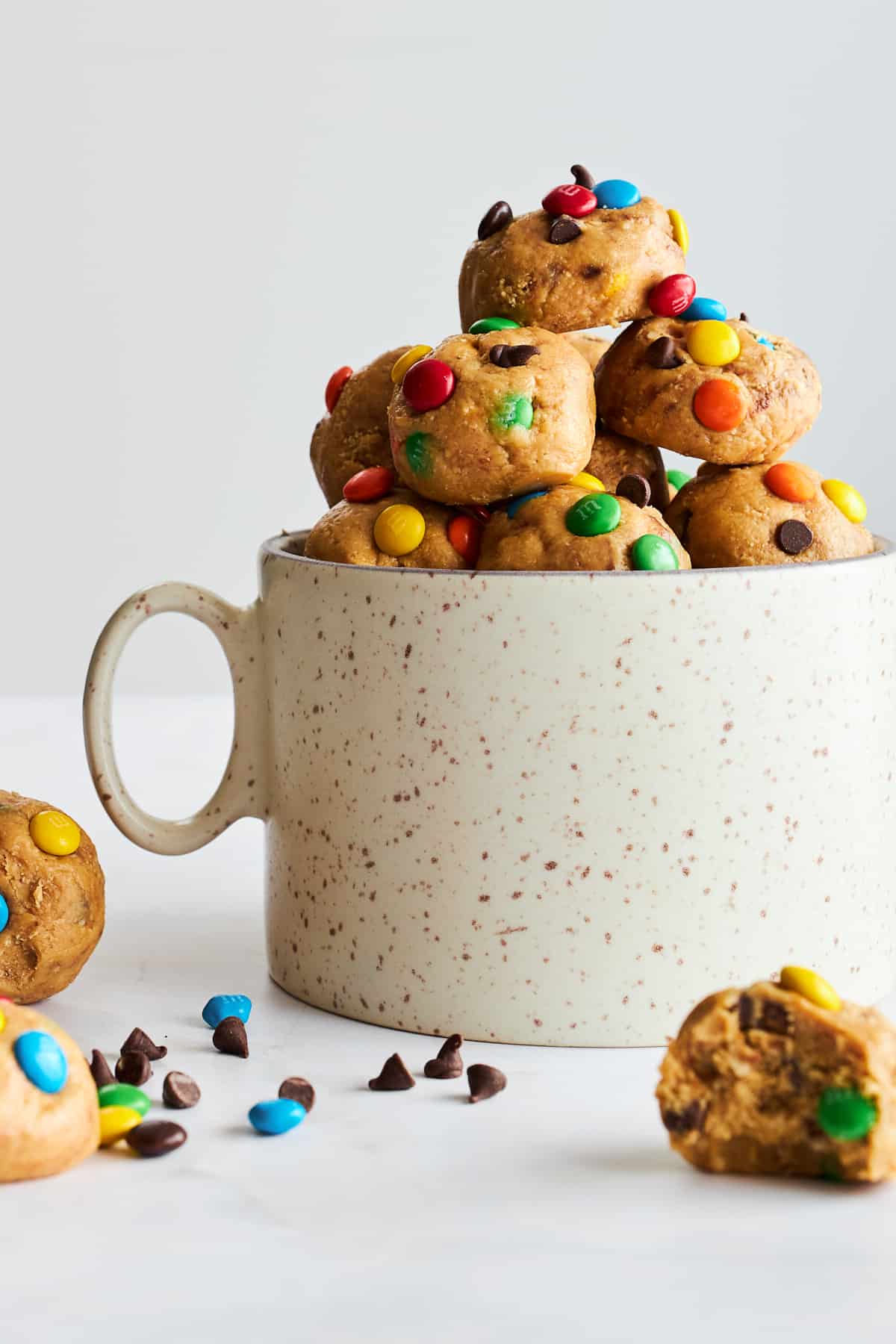 A mug full of no-bake monster cookie dough balls.