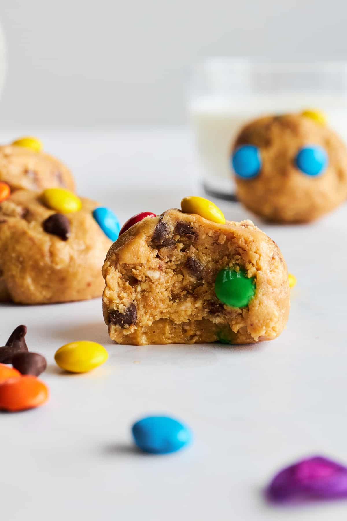 A monster cookie energy bite with a bite missing.