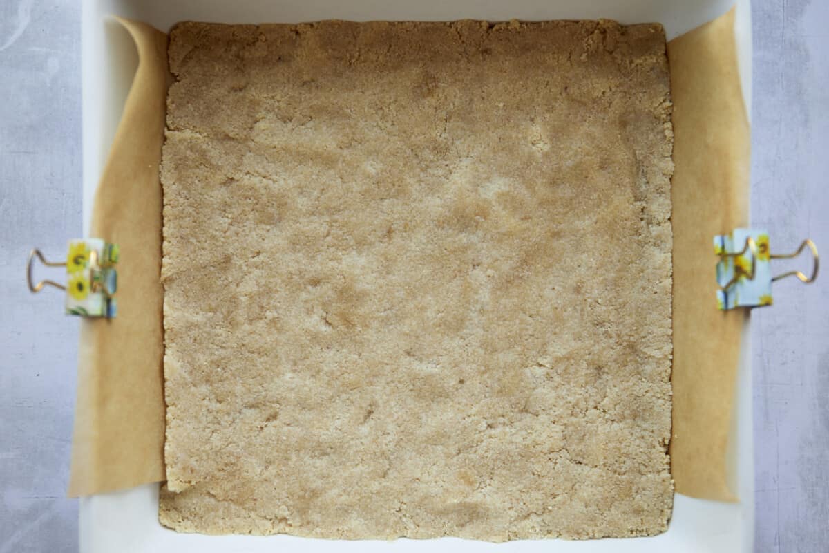Almond flour crust pressed into a baking dish. 