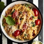 A bowl of Boursin pasta topped with parmesan and fresh basil.