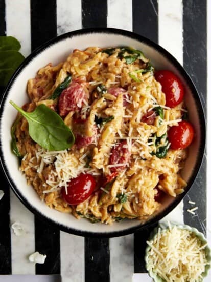A bowl of Boursin pasta topped with parmesan and fresh basil.