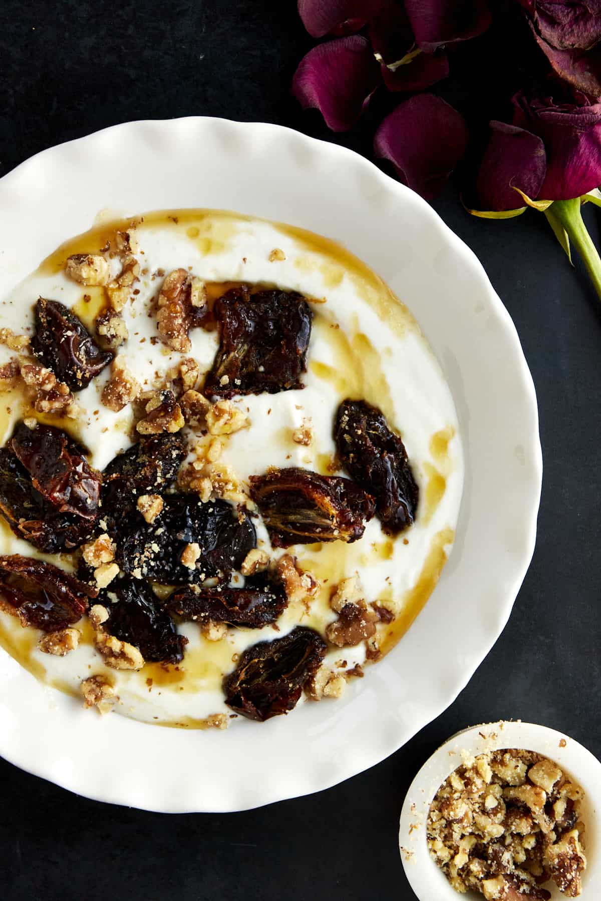 A bowl of honey whipped ricotta topped with roasted dates and walnuts.