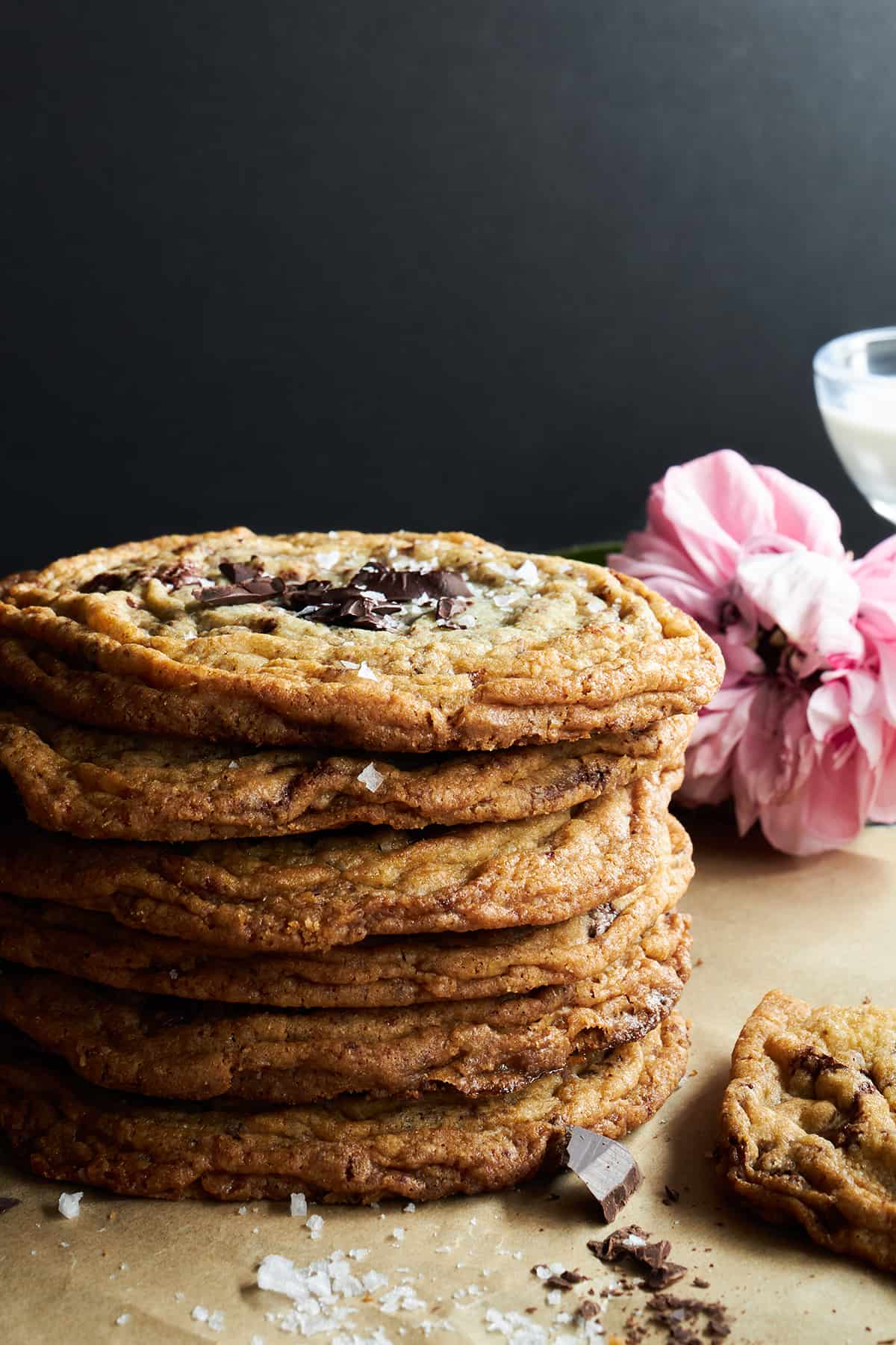 A stack of six pan banging chocolate chip cookies. 