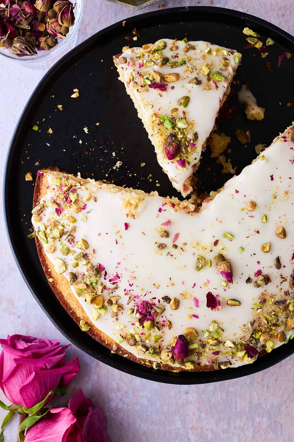 Persian love cake with pieces missing and one piece sliced.