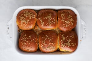 Baked cheesy ground beef sliders in a baking dish.
