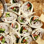 Turkey pinwheel sandwiches on a plate with chips.