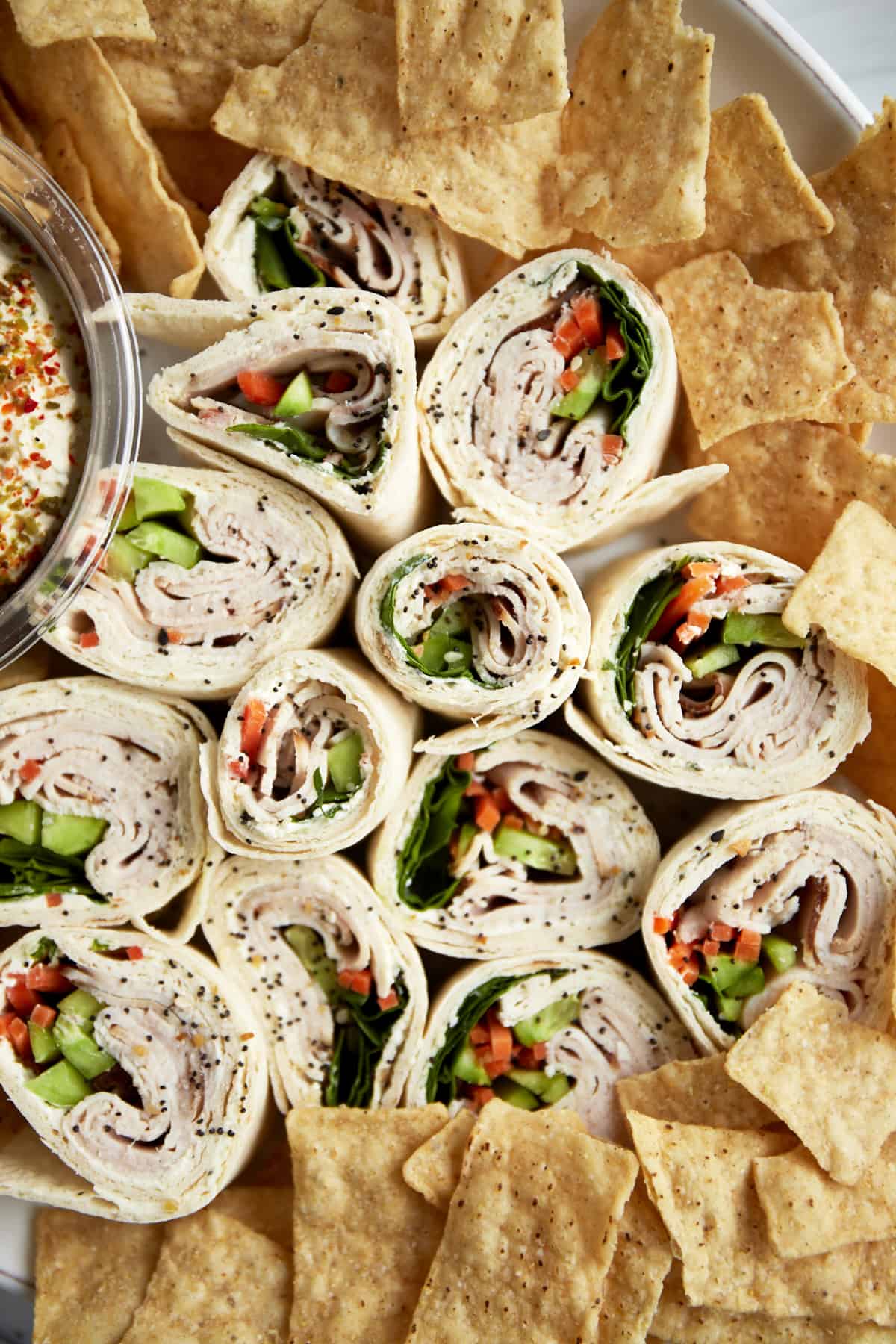Turkey pinwheel sandwiches on a plate with chips.