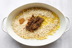 Mashed bananas, oats, date paste, and cinnamon in an oval baking dish.