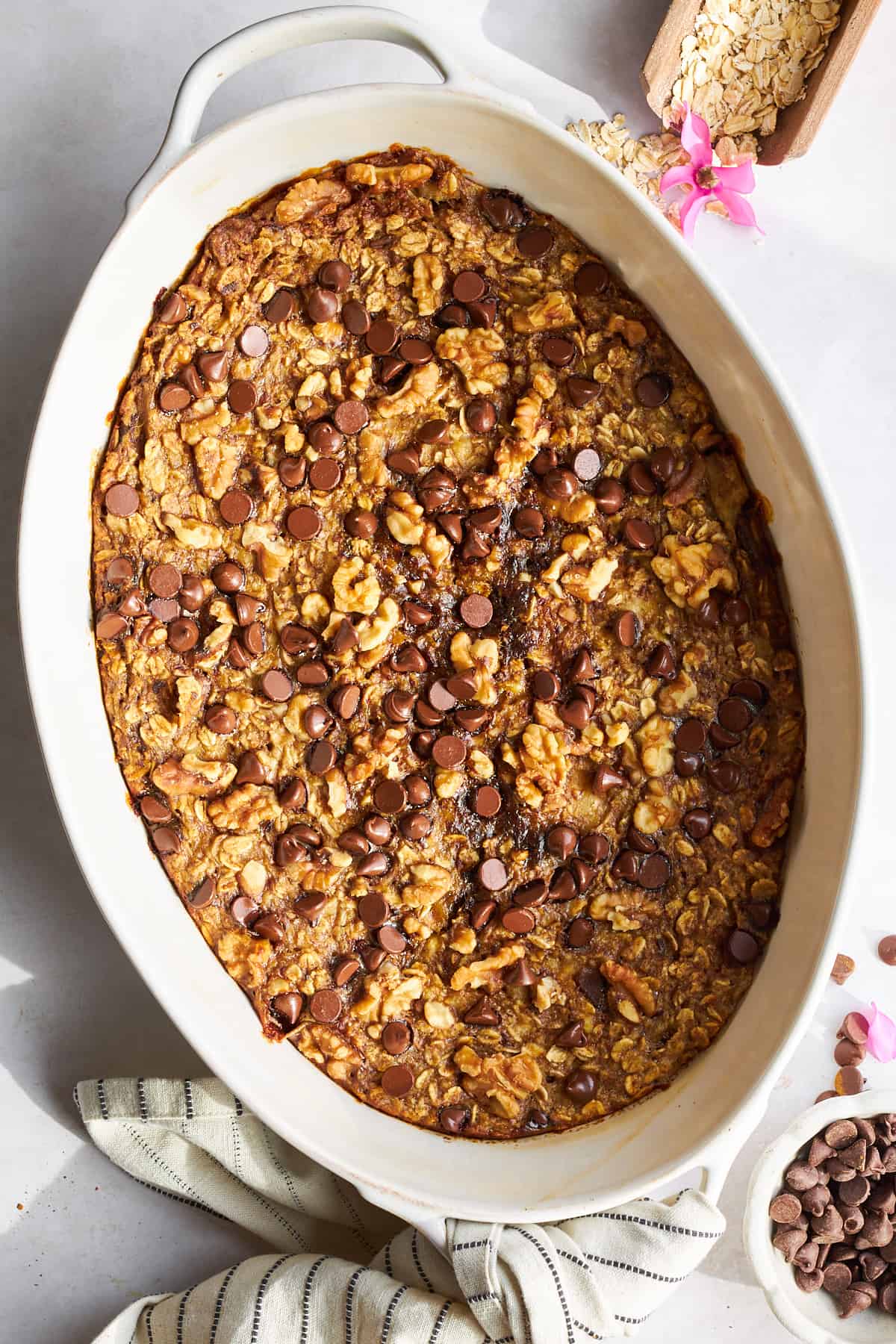 Banana date oatmeal bake with chocolate chips in an oval baking dish. 