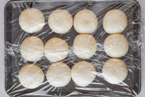 Dinner rolls on a baking sheet being thawed.