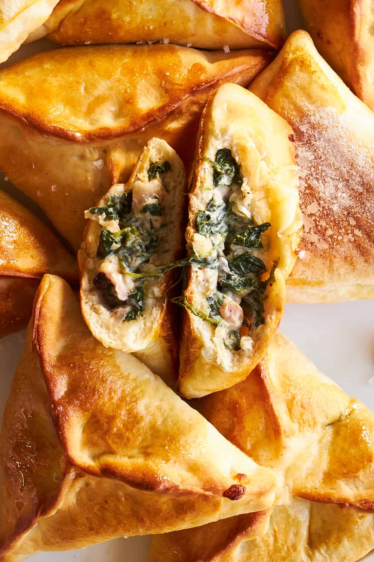Baked spinach and cheese fatayer with one split in half. 