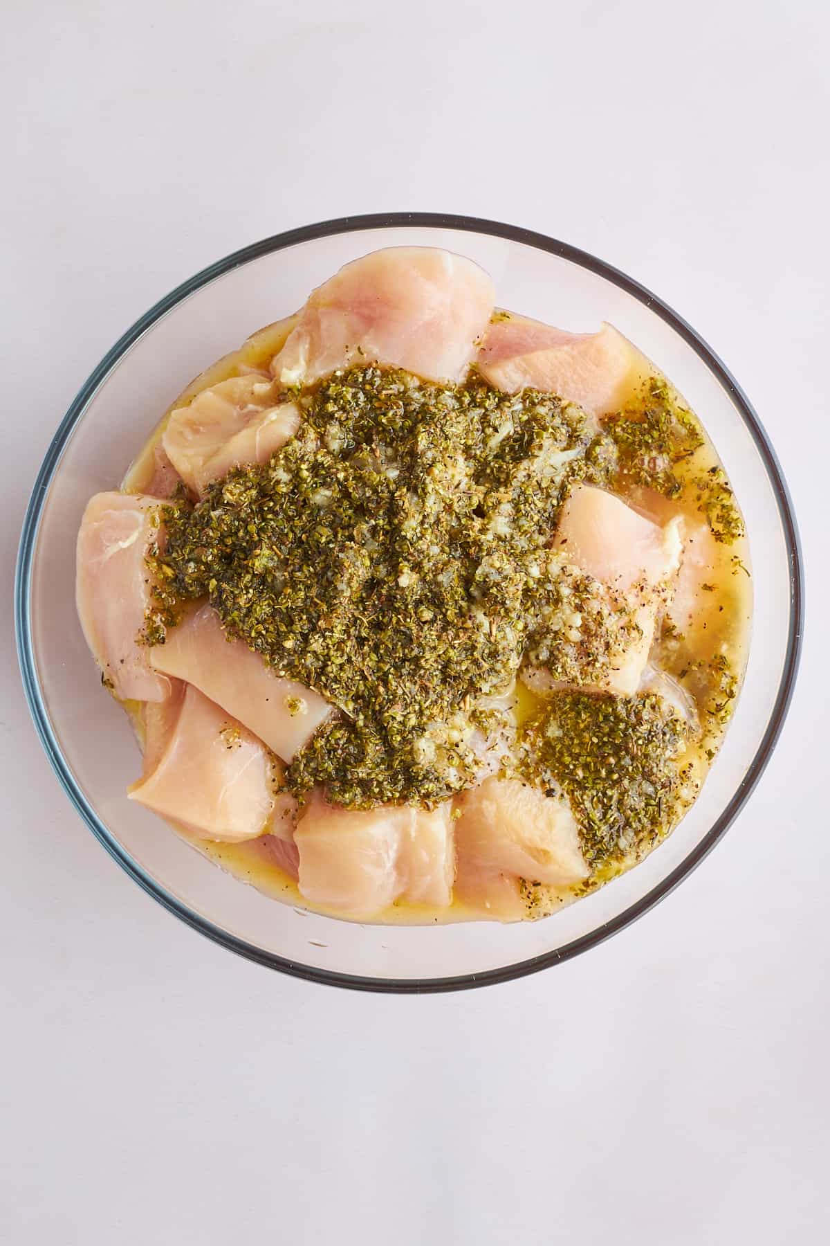 Raw chicken pieces marinading in souvlaki marinade.