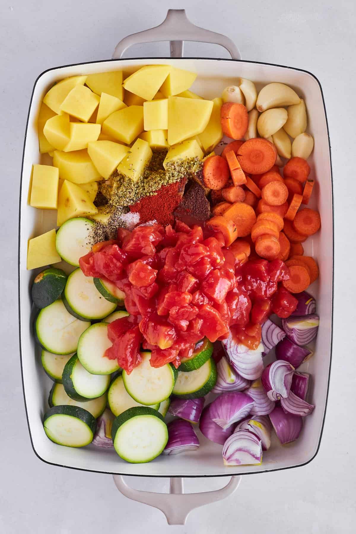 Veggies and spices in a baking dish. 