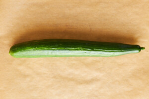 A cucumber on a parchment paper sheet.