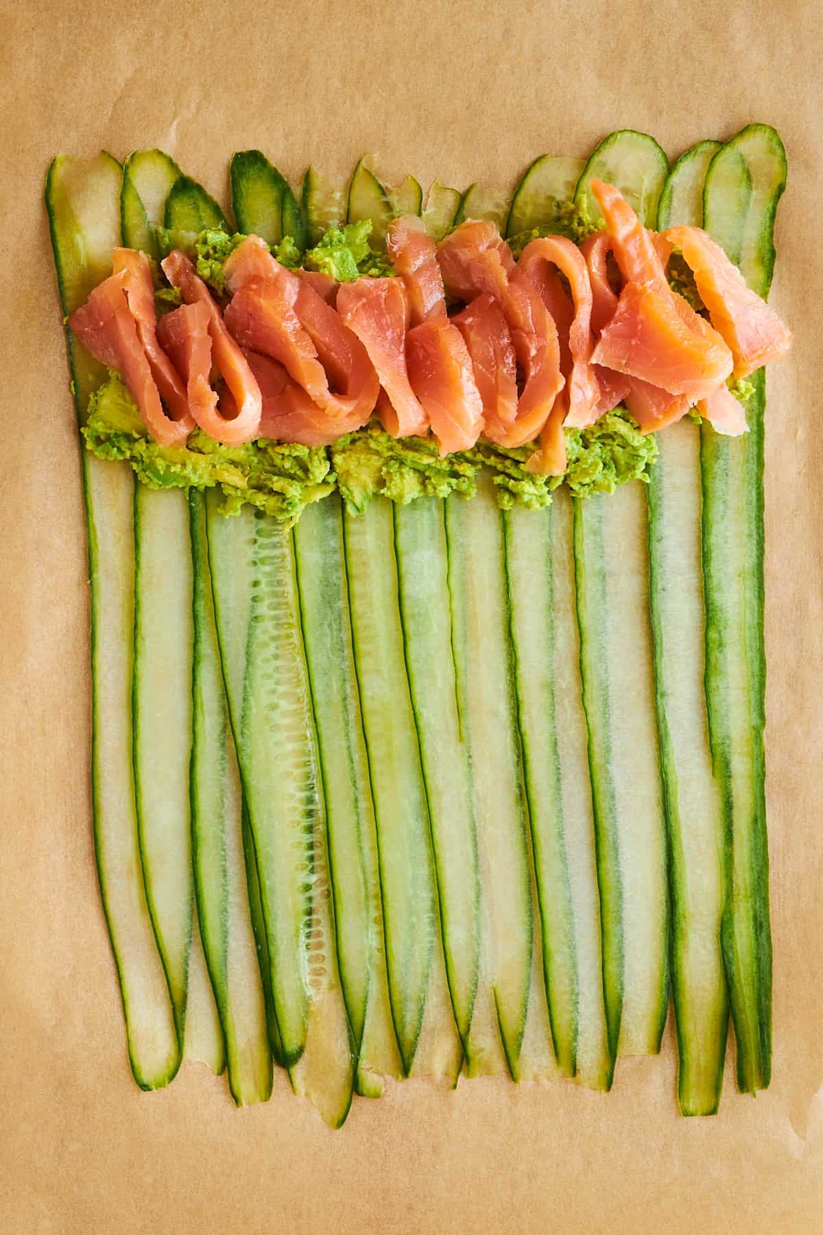 Smashed cucumber and salmon layered over cucumber strips. 