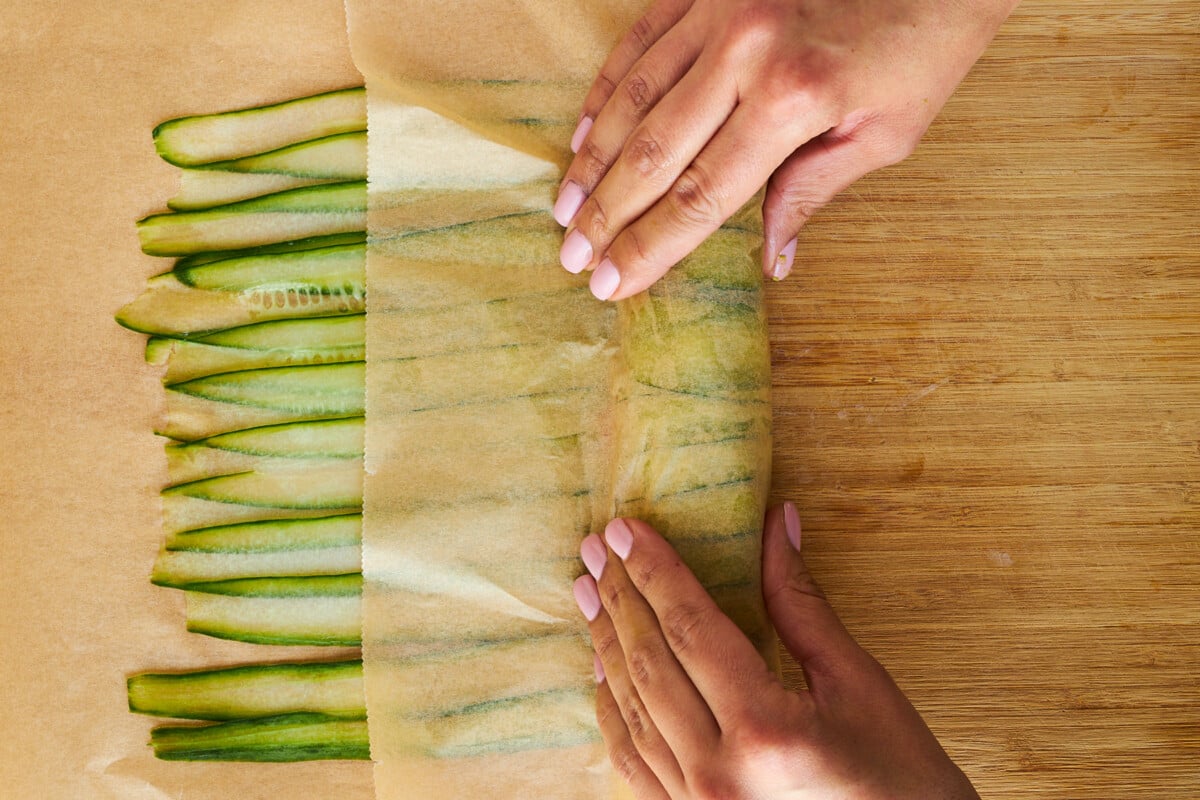 Salmon cucumber roll being rolled.