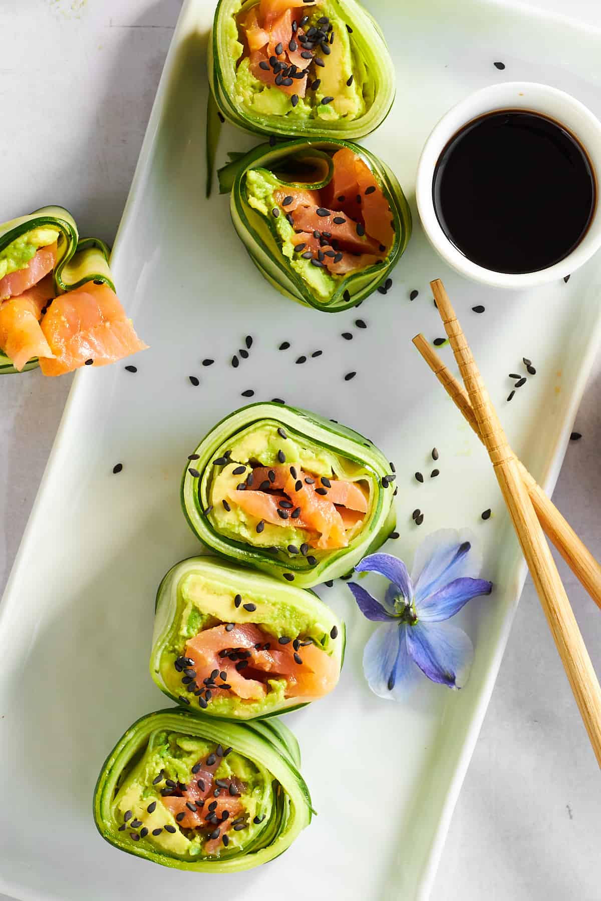 Smoked salmon cucumber rolls on a plate with soy sauce. 