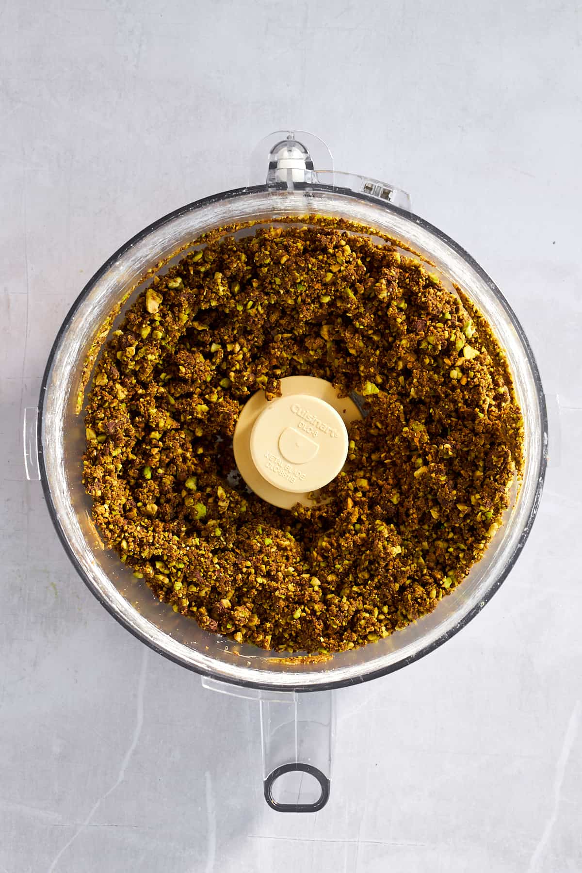 A chocolate and pistachio mixture in a food processor. 
