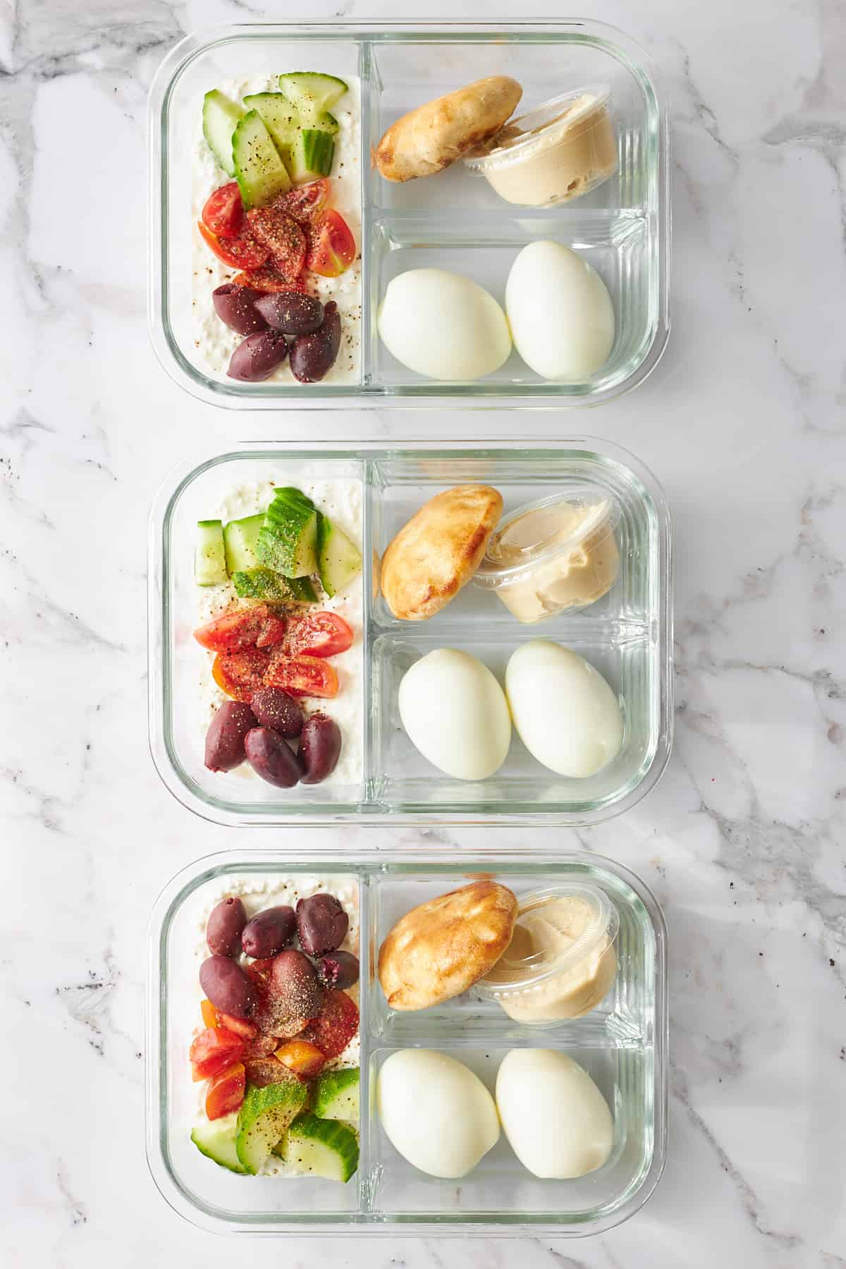 Three containers with meal prep cottage cheese salad. 