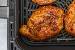 Raw chipotle chicken thighs in an air fryer.