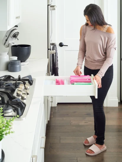 picture of woman in her kitchen with salt by sabrina organizers in her kitchen drawers