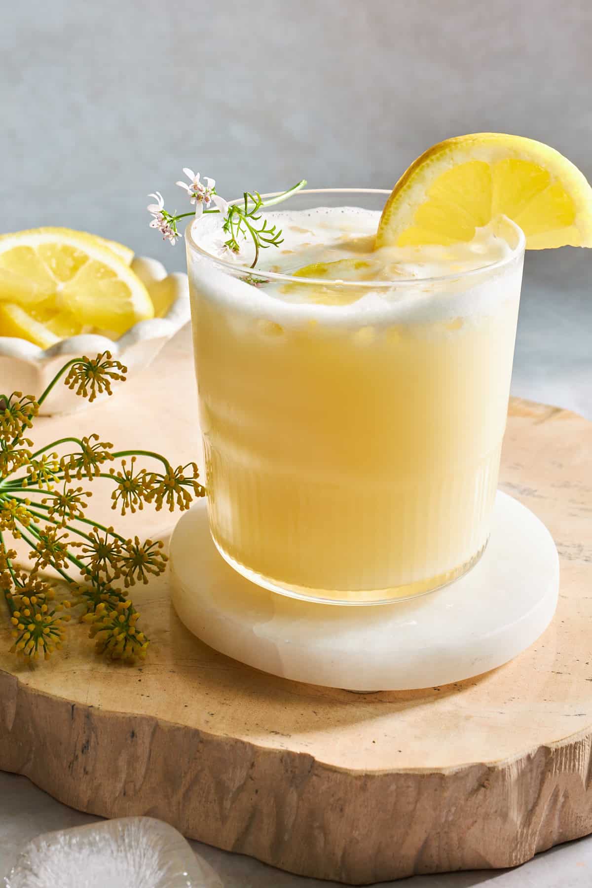 A glass of creamy lemonade with a lemon wedge on the side. 