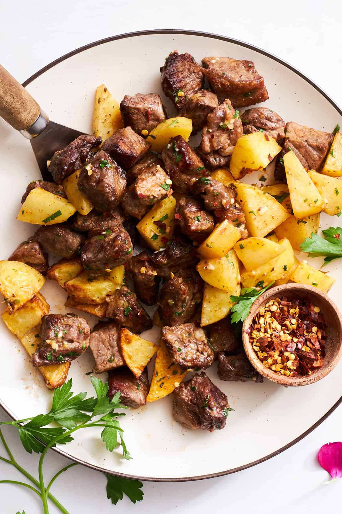A plate of steak bites and potatoes.
