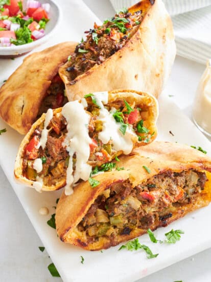 Four Hawawshi pita halves on a plate.