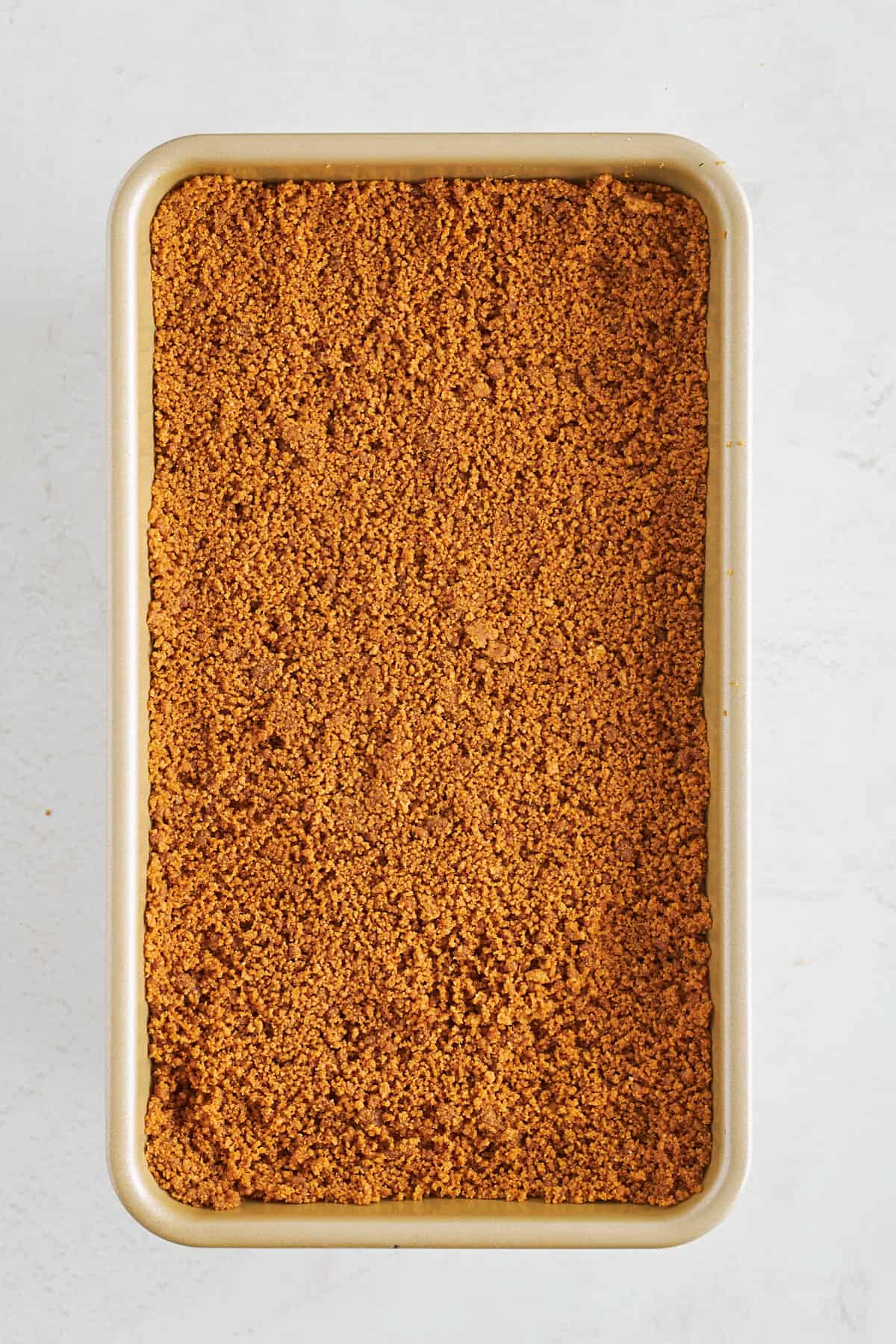 A Biscoff cookie crust covering an upside down cheesecake. 