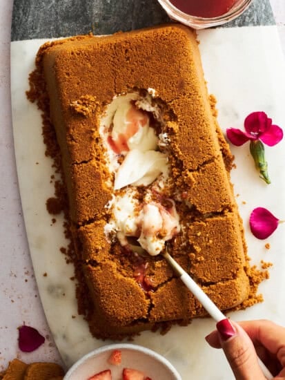 A spoon digging into the center of an upside down cheesecake.