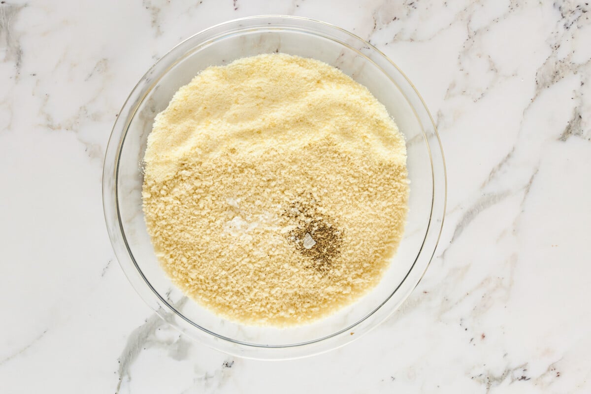 A bowl of breadcrumbs, seasonings, and cheese.