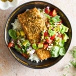 A bowl of white rice with baked salmon and avocado salsa.