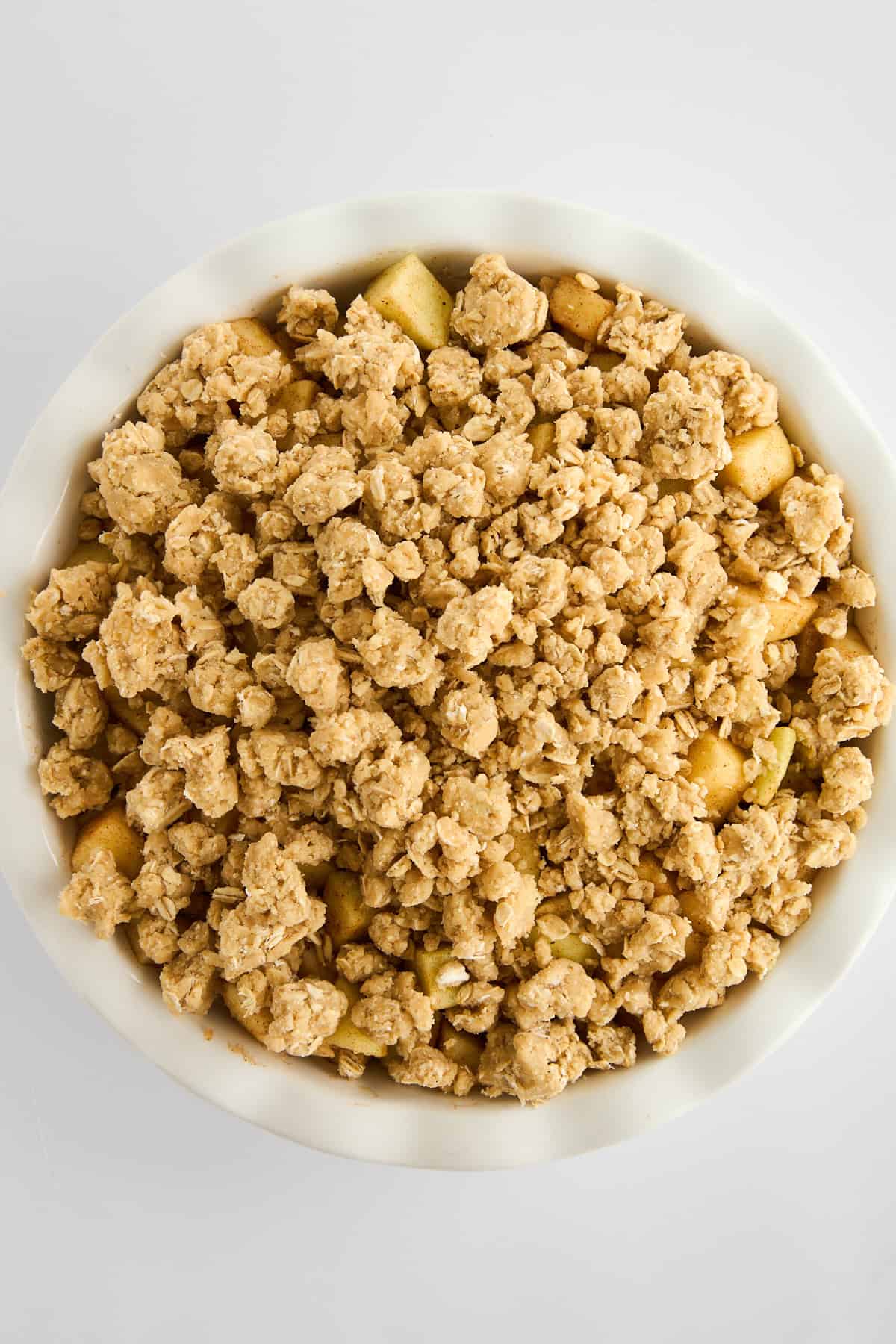 Unbaked apple crisp with an oat topping. 