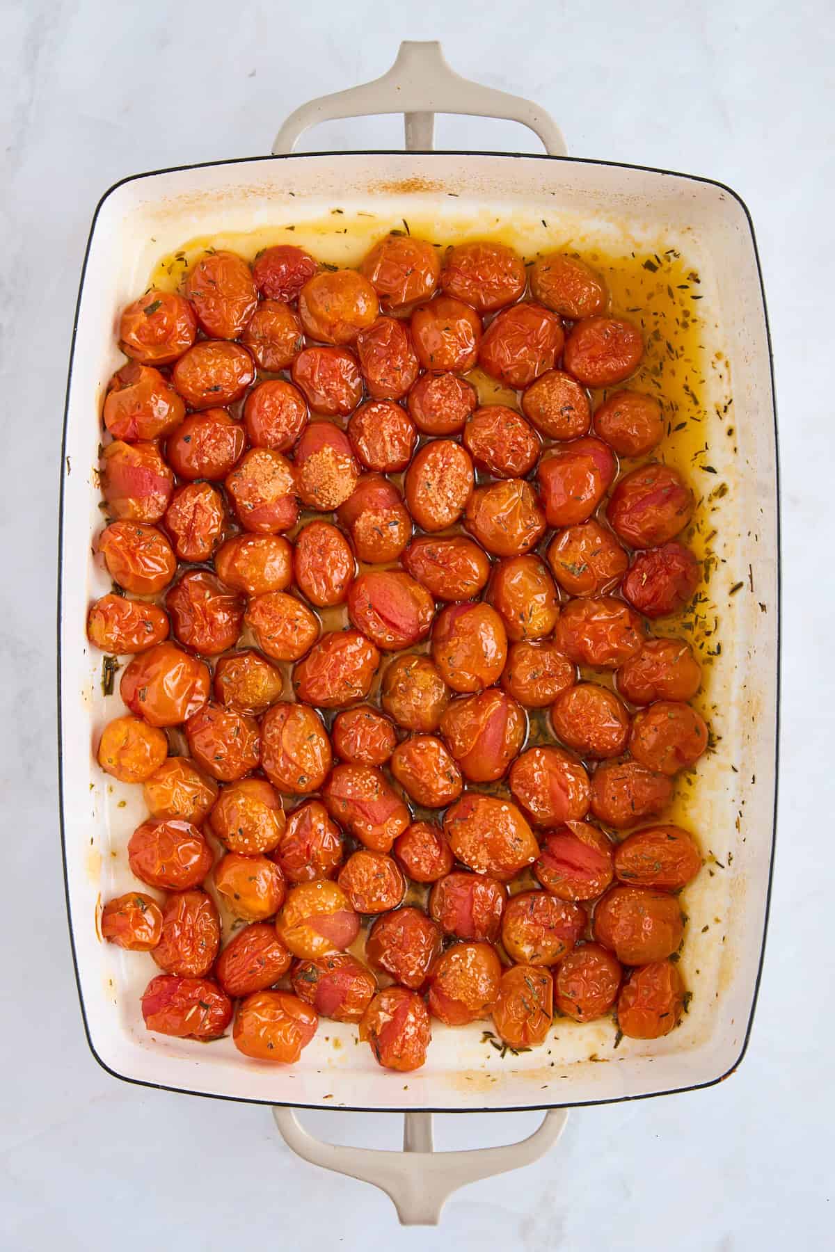 Baked cherry tomatoes in a baking dish.