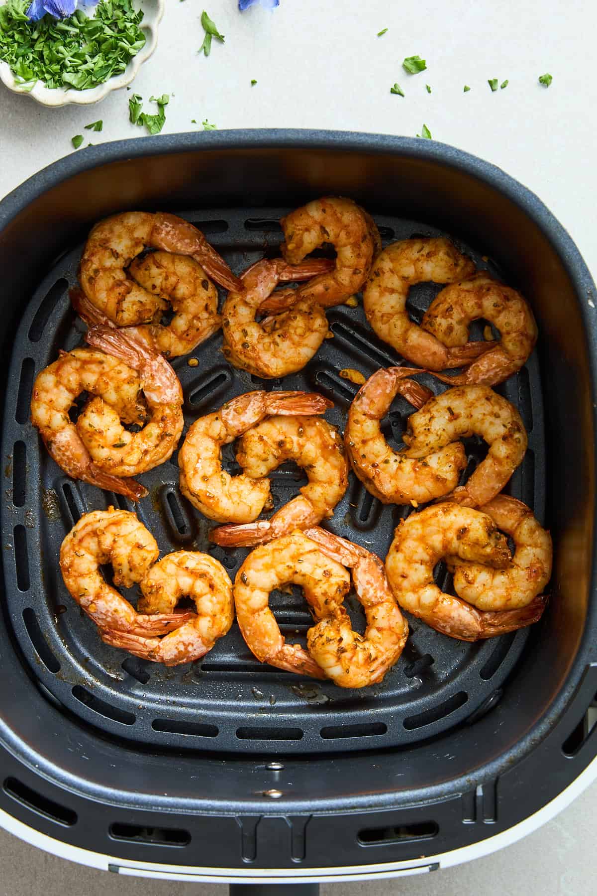 Air fryer shrimp in an air fryer basket.