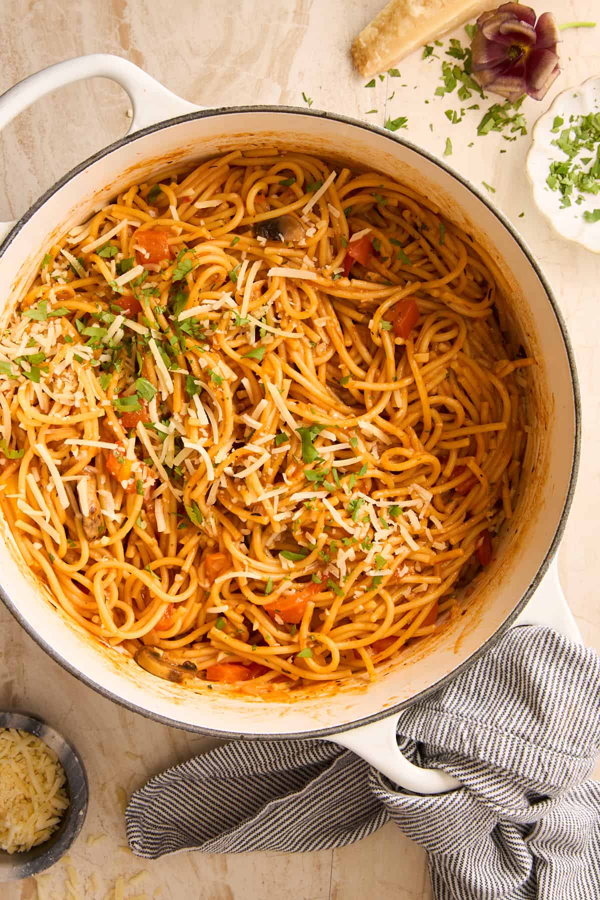 A pot of spaghetti topped with cheese.
