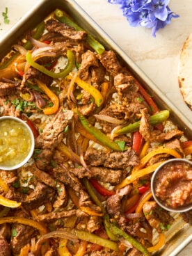 Sheet pan steak fajitas on a baking sheet.