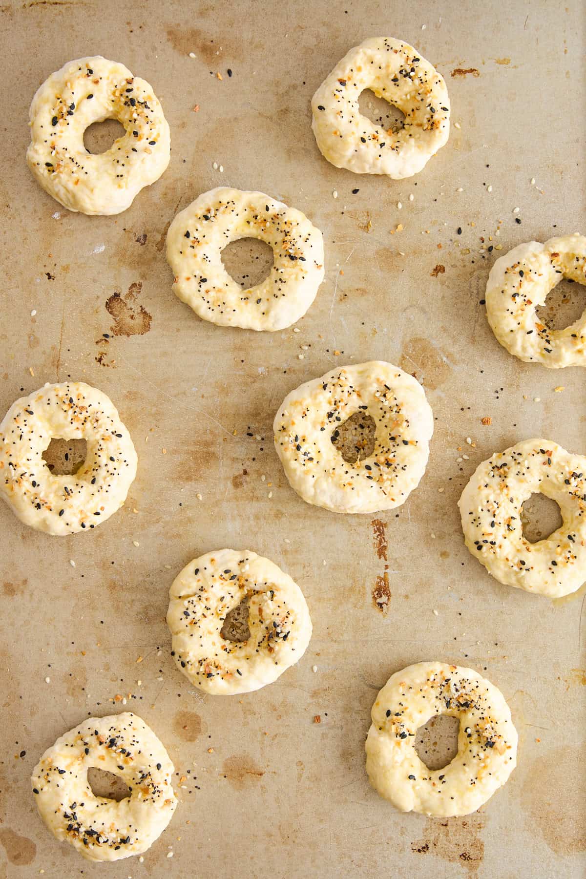 Unbaked cottage cheese bagels topped with egg wash and everything but the bagel seasoning.