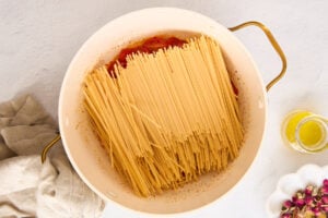 Pasta in a pot with tomatoes and garlic.